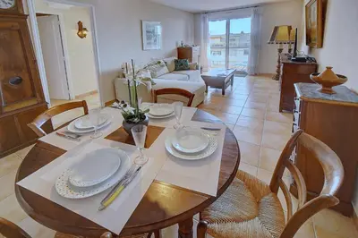 a dining room with a table and chairs and a living room at IMMOGROOM - Terrace- Parking - Quiet place - CONGRESSBEACHES in Cannes