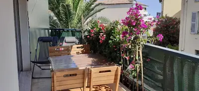 a wooden bench sitting on a balcony with flowers at Appartement raffiné Cannes in Cannes