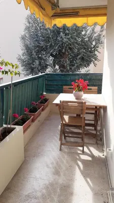 a patio with a table and benches and potted plants at Appartement raffiné Cannes in Cannes