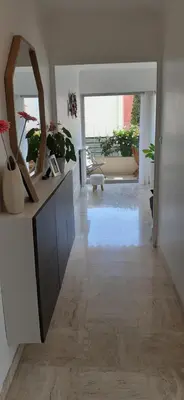 a living room with a large mirror and a hallway at Appartement raffiné Cannes in Cannes