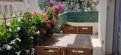 a garden with flowers and a wooden bench at Appartement raffiné Cannes in Cannes