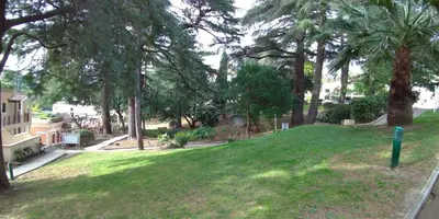 a park with palm trees and a green field at Studio cabine vue mer, piscine panoramique, parking couvert in Cannes