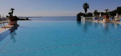a large swimming pool with a view of the ocean at Studio cabine vue mer, piscine panoramique, parking couvert in Cannes