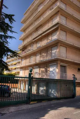 a building with a fence in front of it at BEL APPARTEMENT PROCHE PLAGE ET CENTRE VILLE in Cannes