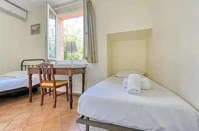 a bedroom with two beds and a desk and a window at L'ORANGER maison pittoresque et confortable proche des plages, Croisette et centre-ville in Cannes