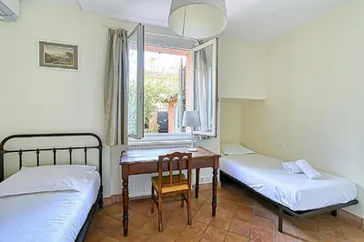 a room with two beds and a desk and a window at L'ORANGER maison pittoresque et confortable proche des plages, Croisette et centre-ville in Cannes