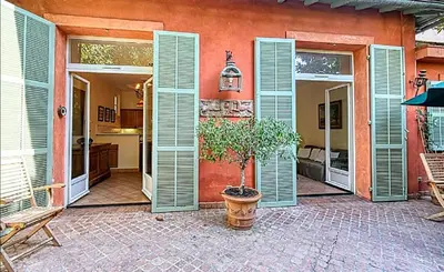 a house with green doors and a potted plant in a courtyard at L'ORANGER maison pittoresque et confortable proche des plages, Croisette et centre-ville in Cannes