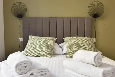 a bed with towels and pillows on top of it at Modern 3-Br Apartment in City Center 5 Minutes from Palais and Beache in Cannes