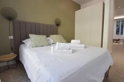 a bedroom with a large white bed with towels on it at Modern 3-Br Apartment in City Center 5 Minutes from Palais and Beache in Cannes