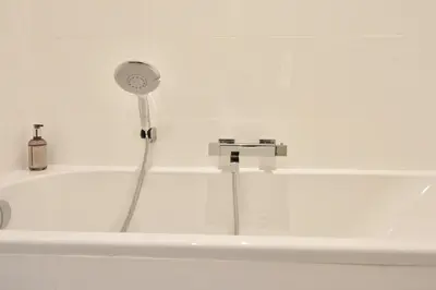 a bath tub with a shower and a faucet at Modern 3-Br Apartment in City Center 5 Minutes from Palais and Beache in Cannes