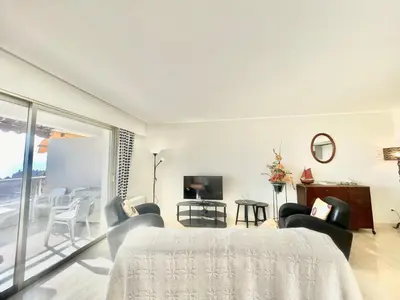 a bedroom with a bed and chairs and a tv at Vezelay, by Welcome to Cannes in Cannes