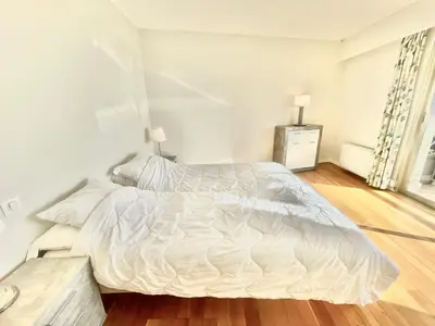 a white bed in a bedroom with a wooden floor at Vezelay, by Welcome to Cannes in Cannes