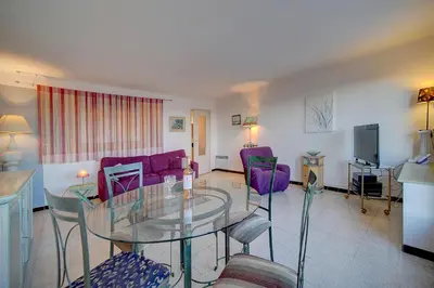 a living room with a glass table and purple chairs at Spacieux 2 Pièces Vue MER, FELIX FAURE- FORVILLE A1B047 in Cannes
