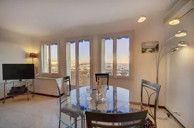 a dining room with a glass table and some windows at Spacieux 2 Pièces Vue MER, FELIX FAURE- FORVILLE A1B047 in Cannes
