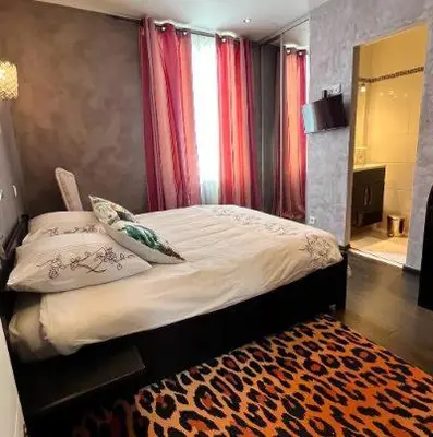 a bedroom with a bed with red curtains and a rug at VILLA BEAUSEJOUR in Cannes