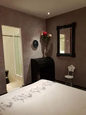 a bedroom with a bed and a mirror and a chair at VILLA BEAUSEJOUR in Cannes