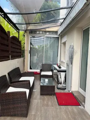 a patio with wicker chairs and a glass table at VILLA BEAUSEJOUR in Cannes