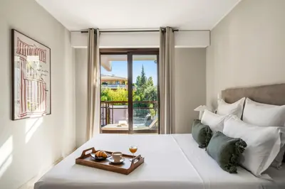 a bedroom with a bed with a tray of food on it at Vivre Cannes l Parking l Balcony l 15min to La Croisette in Cannes