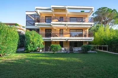 a large yellow building with a yard in front of it at Vivre Cannes l Parking l Balcony l 15min to La Croisette in Cannes