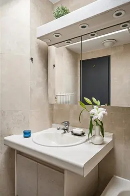 a bathroom with a sink and a vase of flowers at Vivre Cannes l Parking l Balcony l 15min to La Croisette in Cannes