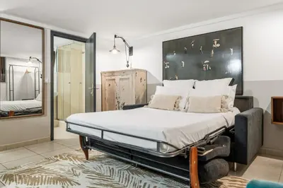 a bedroom with a large bed and a mirror at Vivre Cannes l Parking l Balcony l 15min to La Croisette in Cannes