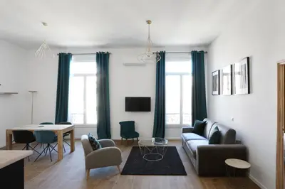 a living room with a couch and a table at Appartement Carnot - Welkeys in Cannes