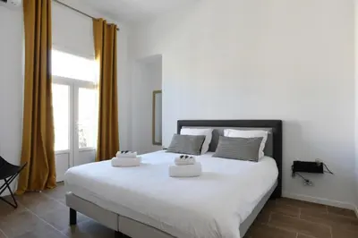 a bedroom with a large white bed with two pillows at Appartement Carnot - Welkeys in Cannes