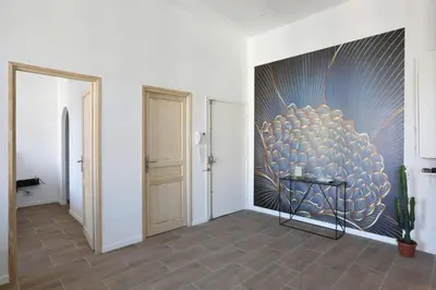 a hallway with a large painting on the wall at Appartement Carnot - Welkeys in Cannes