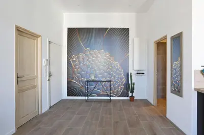 a hallway with a large painting on the wall at Appartement Carnot - Welkeys in Cannes