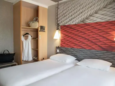 a hotel room with a bed and a table with a tray of food at ibis Cannes Plage La Bocca in Cannes