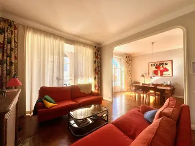 a living room with a red couch and a table at Novembre by Welcome to Cannes in Cannes