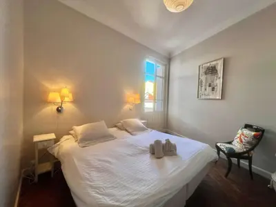 a bedroom with a large white bed with a window at Novembre by Welcome to Cannes in Cannes