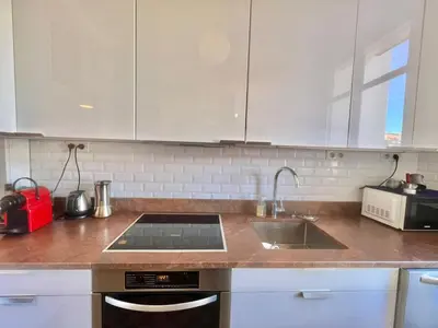 a kitchen with white cabinets and a sink at Novembre by Welcome to Cannes in Cannes