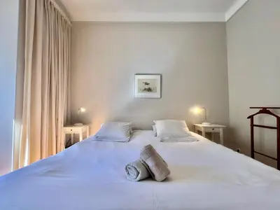 a bedroom with a large white bed with two tables at Novembre by Welcome to Cannes in Cannes