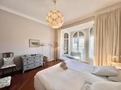 a bedroom with a large white bed and a chandelier at Novembre by Welcome to Cannes in Cannes