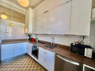 a kitchen with white cabinets and a sink and a microwave at Novembre by Welcome to Cannes in Cannes