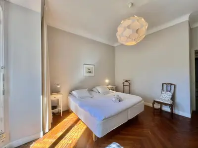 a white bedroom with a bed and a chandelier at Novembre by Welcome to Cannes in Cannes