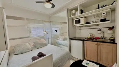a small bedroom with a bed and a kitchen at Minerve by Welcome to Cannes in Cannes