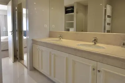 a bathroom with two sinks and a large mirror at Close to downtown Cannes swimming pool and sea view in Cannes