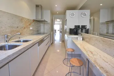 a kitchen with a sink and a counter with stools at Close to downtown Cannes swimming pool and sea view in Cannes