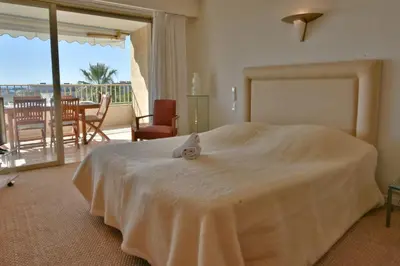 a bedroom with a large bed with a view of a patio at Close to downtown Cannes swimming pool and sea view in Cannes