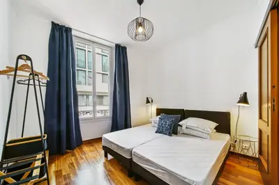 a bedroom with a bed and a large window at Charmant 3 pièces rue d'Antibes in Cannes