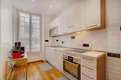 a kitchen with white cabinets and a window at Charmant 3 pièces rue d'Antibes in Cannes