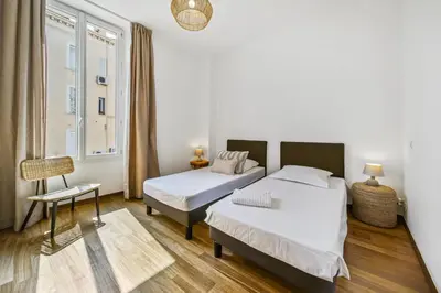 a bedroom with two beds and a window at Charmant 3 pièces rue d'Antibes in Cannes