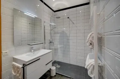 a white bathroom with a sink and a mirror at Charmant 3 pièces rue d'Antibes in Cannes