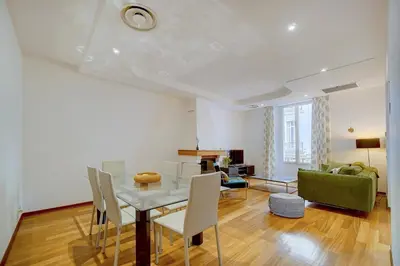a living room with a table and a green couch at Charmant 3 pièces rue d'Antibes in Cannes