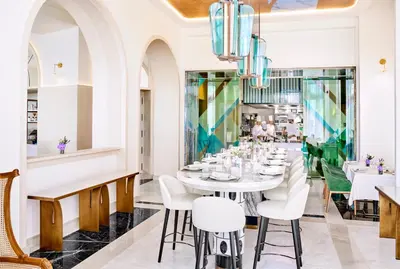 a dining room with a white table and chairs at Carlton Cannes, a Regent Hotel in Cannes