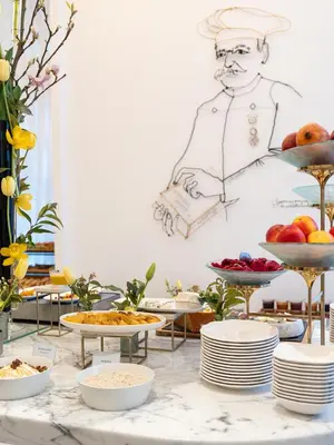 a table with plates of food and a drawing of a chef at Carlton Cannes, a Regent Hotel in Cannes