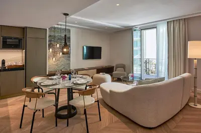 a living room with a table and chairs at Carlton Cannes, a Regent Hotel in Cannes