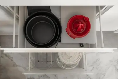 two dishes are sitting on a shelf in a closet at Appartement 2 pièces au calme proche Martinez avec parking privé in Cannes
